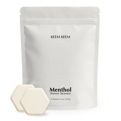 Minimalist stand-up pouch of Keem Keem Menthol Shower Steamers with two hexagon tablets displayed in front, showcasing clean packaging and product size.