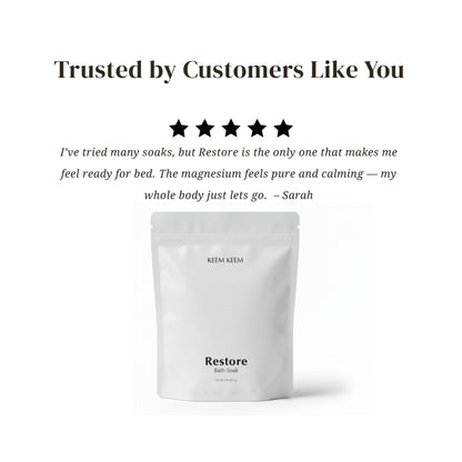 Editorial testimonial image for Keem Keem Restore Bath Soak featuring a 5-star review highlighting magnesium’s calming effect and showing the minimal white pouch packaging.